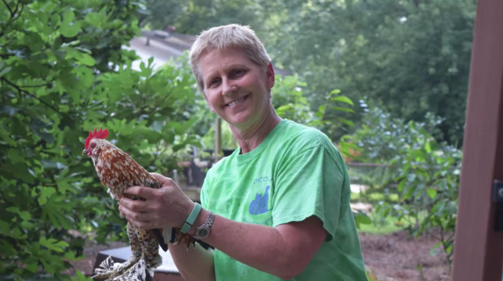 pros and cons of living in raleigh nc: pro is a picture of a woman holding her chicken that she keeps in her backyard