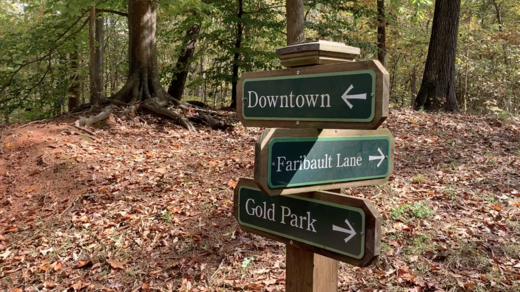 Signs on the trail point to Gold Park and Downtown Hillsborough.