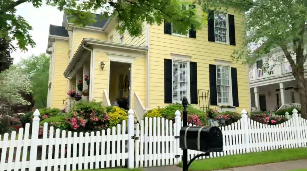 Yellow home with white picket fence in Carpenter Village, Cary NC